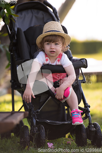 Image of baby girl sitting in the baby stroller