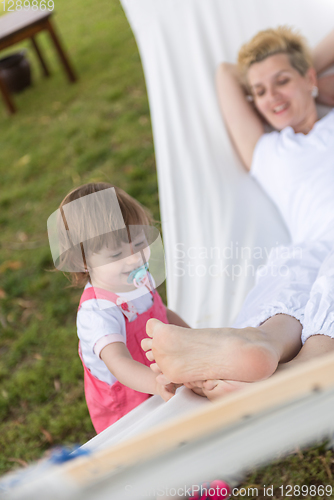 Image of mother and a little daughter relaxing in a hammock