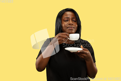 Image of Young african woman isolated on yellow studio background, facial expression