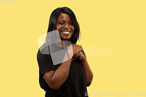 Image of Young african woman isolated on yellow studio background, facial expression