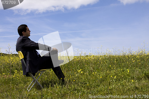 Image of Businessman sitting in a yellow chair