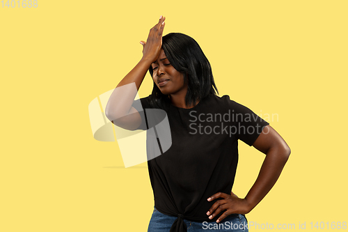 Image of Young african woman isolated on yellow studio background, facial expression