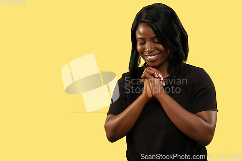 Image of Young african woman isolated on yellow studio background, facial expression