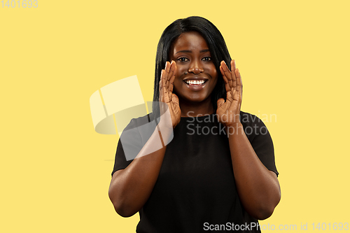 Image of Young african woman isolated on yellow studio background, facial expression