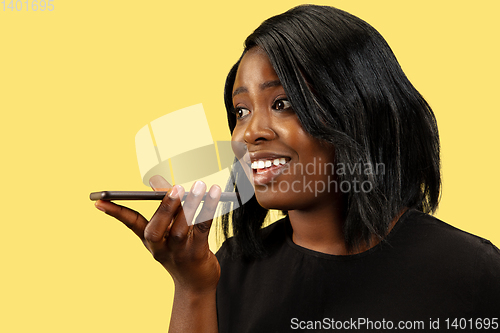 Image of Young african woman isolated on yellow studio background, facial expression
