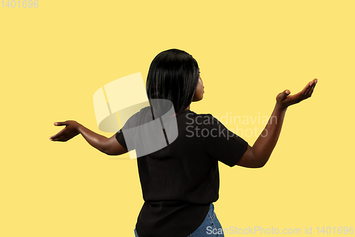 Image of Young african woman isolated on yellow studio background, facial expression