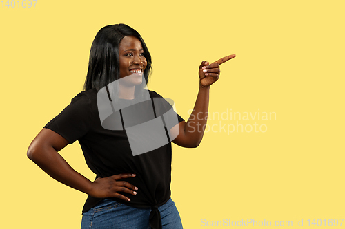 Image of Young african woman isolated on yellow studio background, facial expression