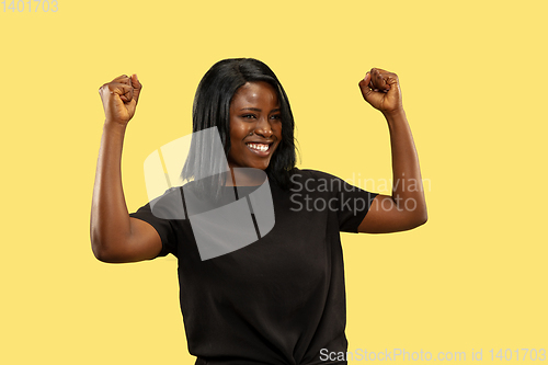 Image of Young african woman isolated on yellow studio background, facial expression