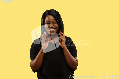 Image of Young african woman isolated on yellow studio background, facial expression