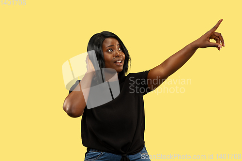 Image of Young african woman isolated on yellow studio background, facial expression