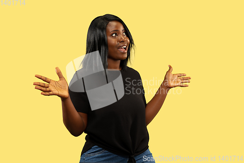 Image of Young african woman isolated on yellow studio background, facial expression