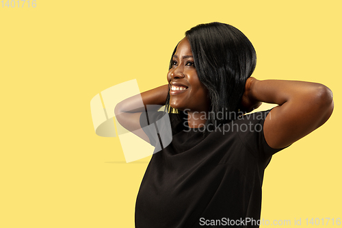 Image of Young african woman isolated on yellow studio background, facial expression