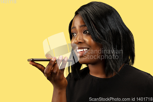 Image of Young african woman isolated on yellow studio background, facial expression