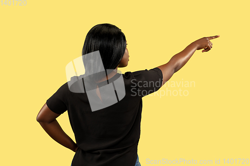 Image of Young african woman isolated on yellow studio background, facial expression