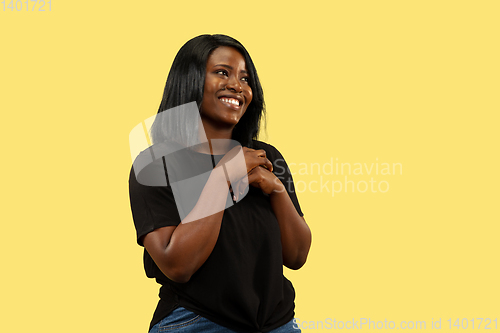 Image of Young african woman isolated on yellow studio background, facial expression
