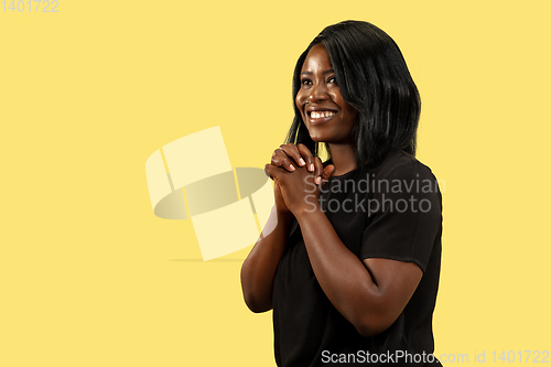 Image of Young african woman isolated on yellow studio background, facial expression