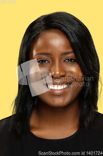 Image of Young african woman isolated on yellow studio background, facial expression