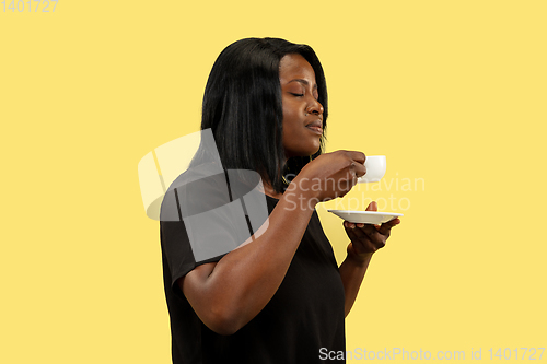Image of Young african woman isolated on yellow studio background, facial expression