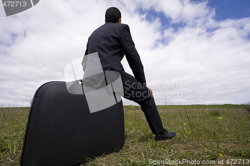 Image of businessman sit in his baggage 