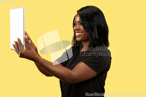 Image of Young african woman isolated on yellow studio background, facial expression