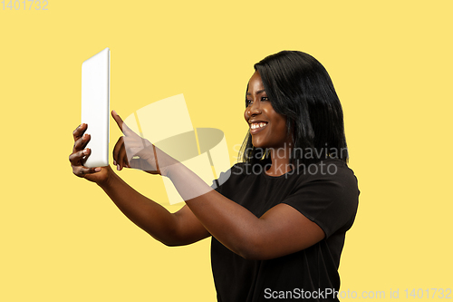 Image of Young african woman isolated on yellow studio background, facial expression