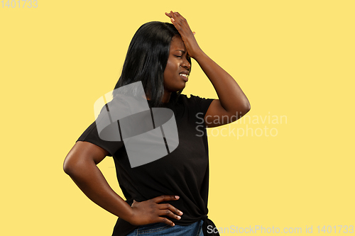 Image of Young african woman isolated on yellow studio background, facial expression
