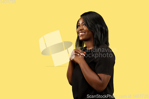 Image of Young african woman isolated on yellow studio background, facial expression