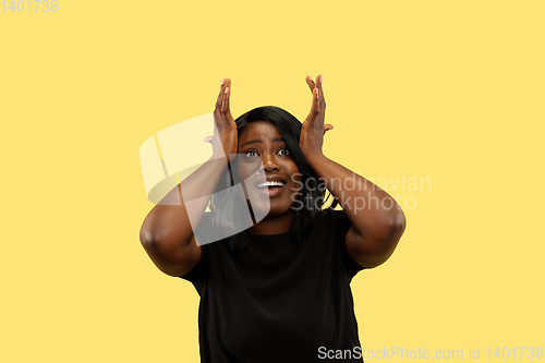 Image of Young african woman isolated on yellow studio background, facial expression