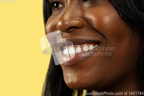 Image of Young african woman isolated on yellow studio background, facial expression