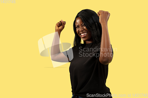 Image of Young african woman isolated on yellow studio background, facial expression