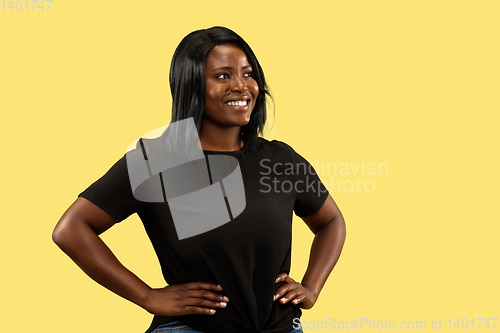 Image of Young african woman isolated on yellow studio background, facial expression