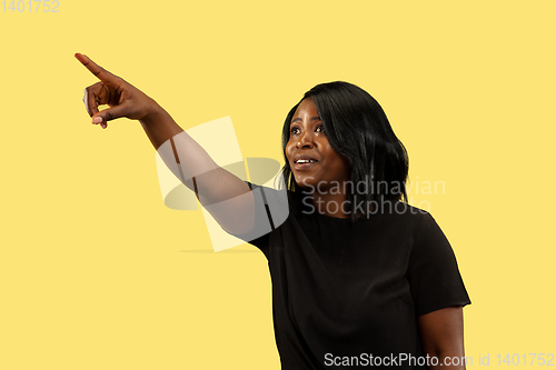 Image of Young african woman isolated on yellow studio background, facial expression