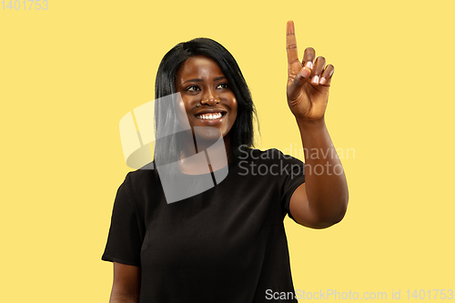 Image of Young african woman isolated on yellow studio background, facial expression