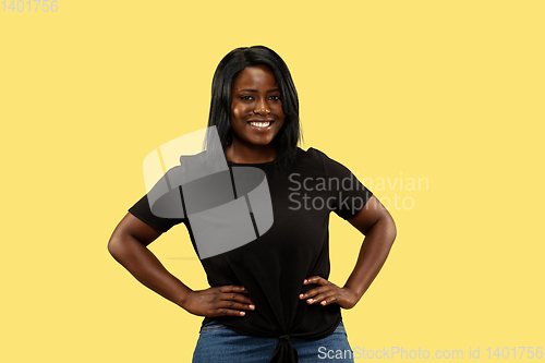 Image of Young african woman isolated on yellow studio background, facial expression