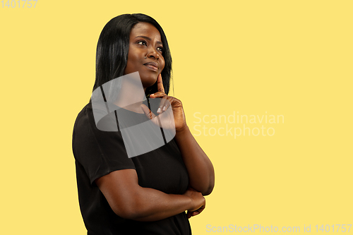 Image of Young african woman isolated on yellow studio background, facial expression