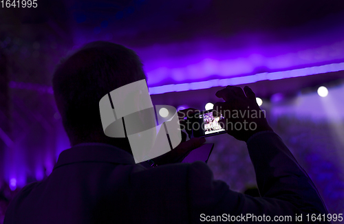 Image of Man taking pictures during a concert