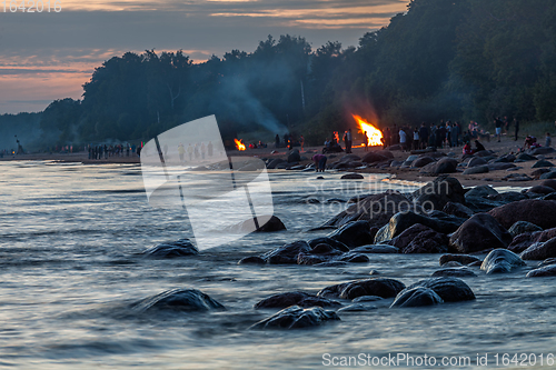 Image of Unrecognisable people celebrating summer solstice with bonfires on beach