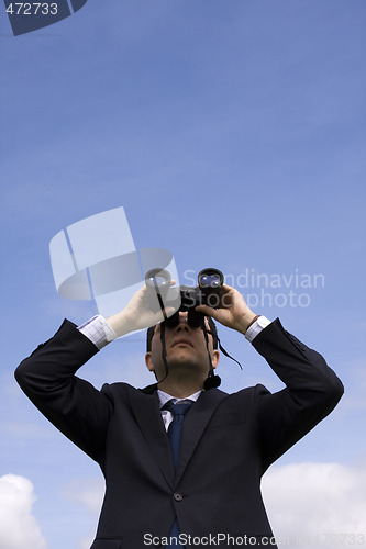 Image of Businessman looking through binoculars