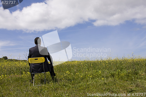 Image of Businessman sit in a yellow chair