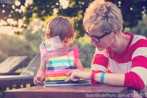 Image of mom and her little daughter using tablet computer