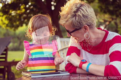 Image of mom and her little daughter using tablet computer