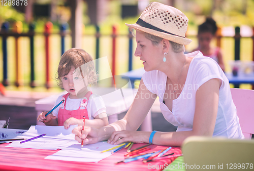 Image of mom and little daughter drawing a colorful pictures