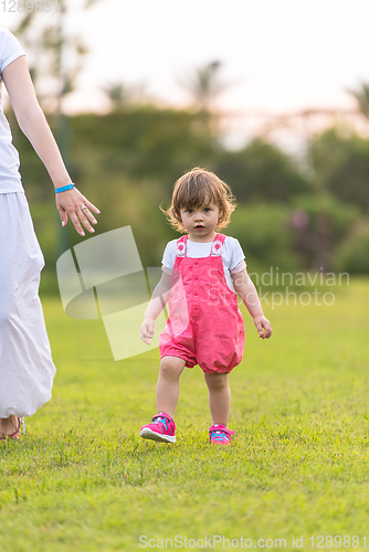 Image of mother and little daughter playing at backyard