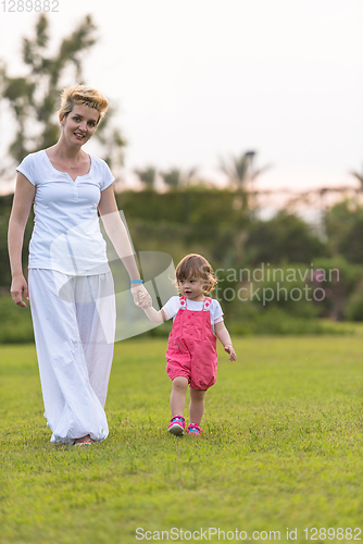 Image of mother and little daughter playing at backyard
