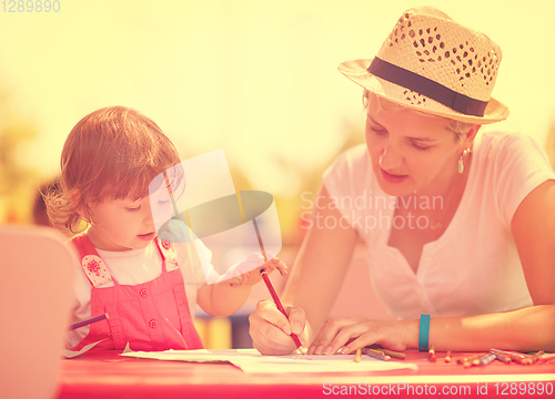 Image of mom and little daughter drawing a colorful pictures