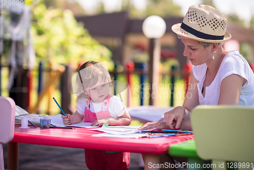 Image of mom and little daughter drawing a colorful pictures