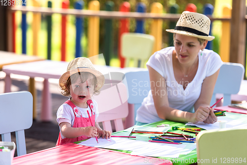 Image of mom and little daughter drawing a colorful pictures