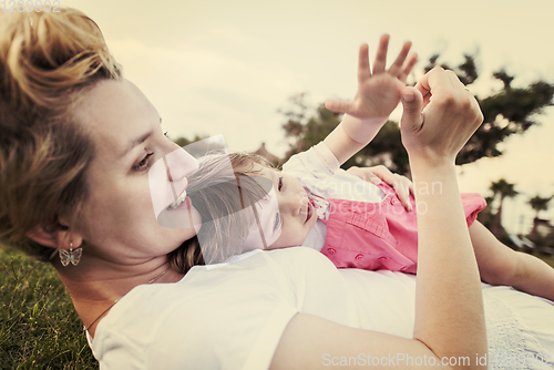 Image of mother and little daughter playing at backyard