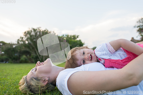 Image of mother and little daughter playing at backyard