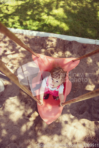 Image of little girl swinging  on a playground